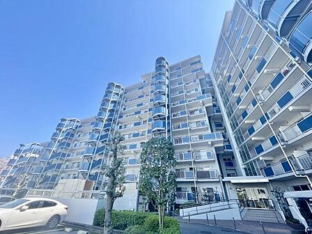 清潔感のある外観が印象的なマンションです。明るい空と調和したデザインでゆったりとした敷地に建っています。共用部分も整備されており車両の出入りもスムーズです。全体的に落ち着いた雰囲気が漂っています。