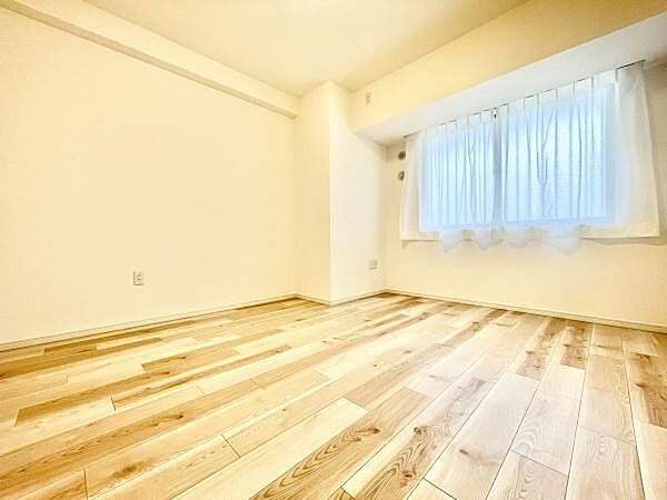 明るい日差しが差し込む寝室です。ナチュラルなフローリングが空間に温かみを与えています。窓際はゆったりとした雰囲気です。シンプルな内装でさまざまなインテリアに調和します。清潔感のある造りも特徴です。