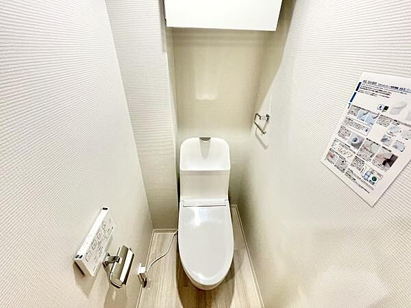 清潔感のある空間が広がるトイレです。壁面デザインも落ち着いた印象です。設備が整理されていて利用しやすいレイアウトとなっています。床材の色合いも空間全体を明るくしています。