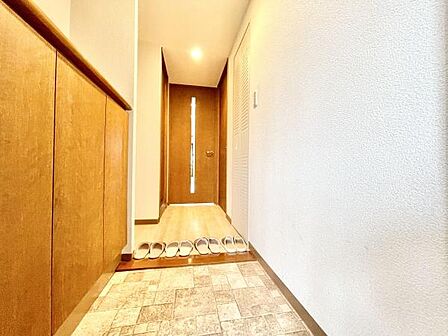 明るく爽やかな玄関が広がります。白を基調とした壁と木目のドアが調和しすっきりとした印象です。収納スペースがしっかり確保されていて整理整頓しやすいです。