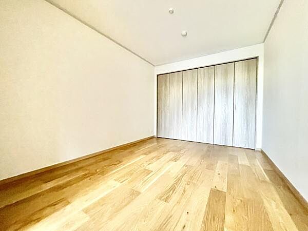 明るいフローリングが印象的な寝室です。大きなクローゼットが備わっており収納スペースも充実しています。シンプルなデザインで多様なインテリアとの相性が良い空間です。
