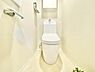 トイレ：明るい色合いでまとめられたトイレ空間です。清潔感を感じる内装が特徴的です。収納棚やペーパーホルダーが設置されています。床や壁もシンプルなデザインとなっています。
