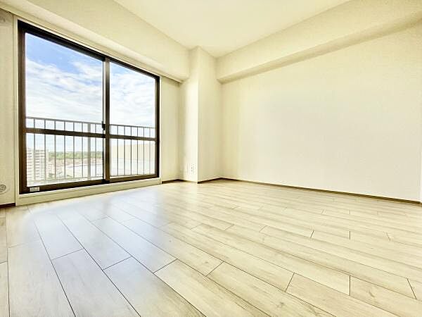 大きな窓から自然光が差し込む明るい寝室です。床は清潔感のあるフローリングでお手入れも簡単です。シンプルな内装がインテリアを引き立てます。バルコニーに面しているため開放感があります。