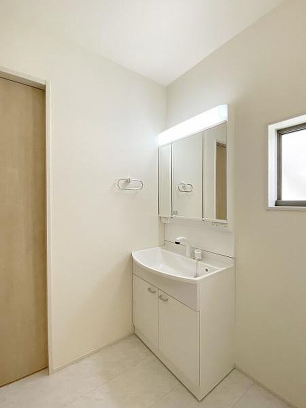 三面鏡付きの洗面台です。鏡裏にも収納可能。洗面室には窓があるので採光・換気に便利です。
