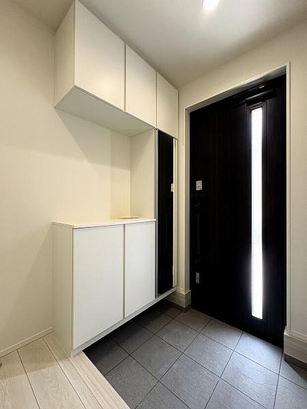 スリットガラスから光が差し込む玄関内。シューズボックスは姿見付きなのでお出かけ前の身だしなみチェックができます。