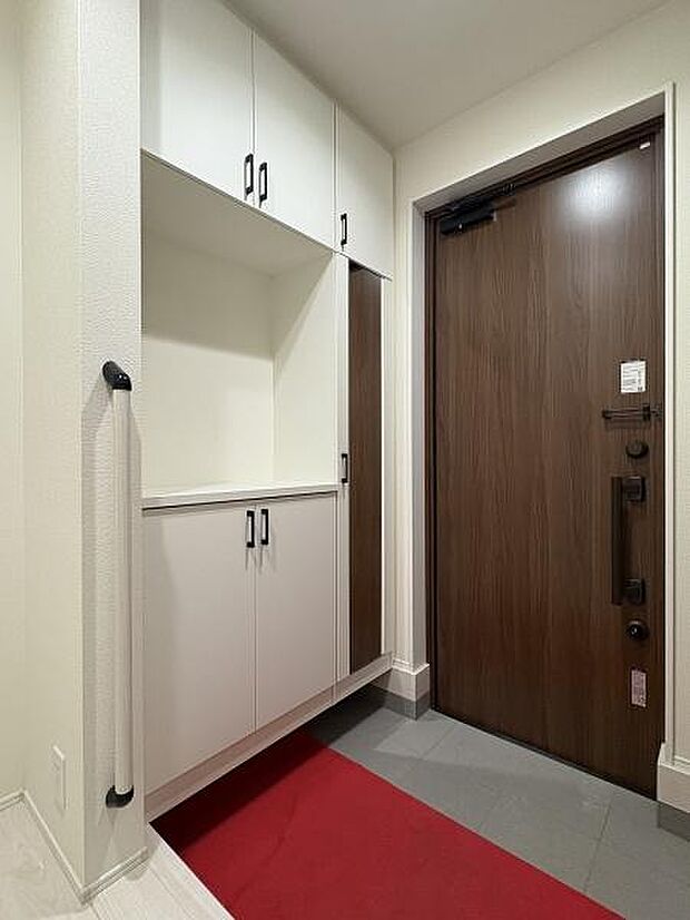 たっぷり収納できるシューズボックスを備えた玄関内。手すり付きで安心です。