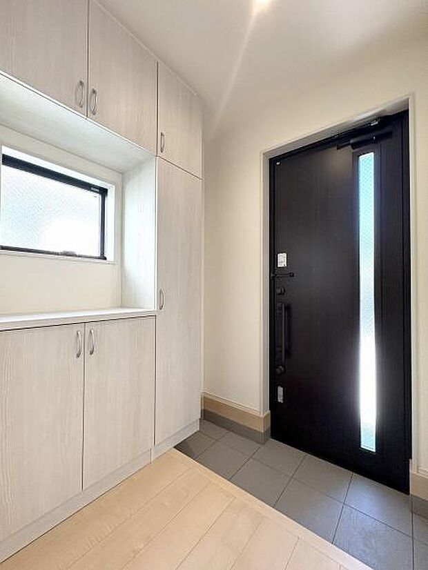 たっぷりと収納できるシューズボックスを備えた玄関。窓があるので明るく、換気にも便利です。