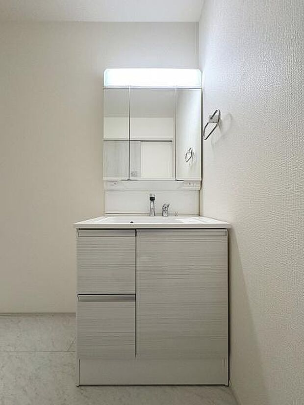 三面鏡付きの洗面台です。鏡裏にも収納可能。