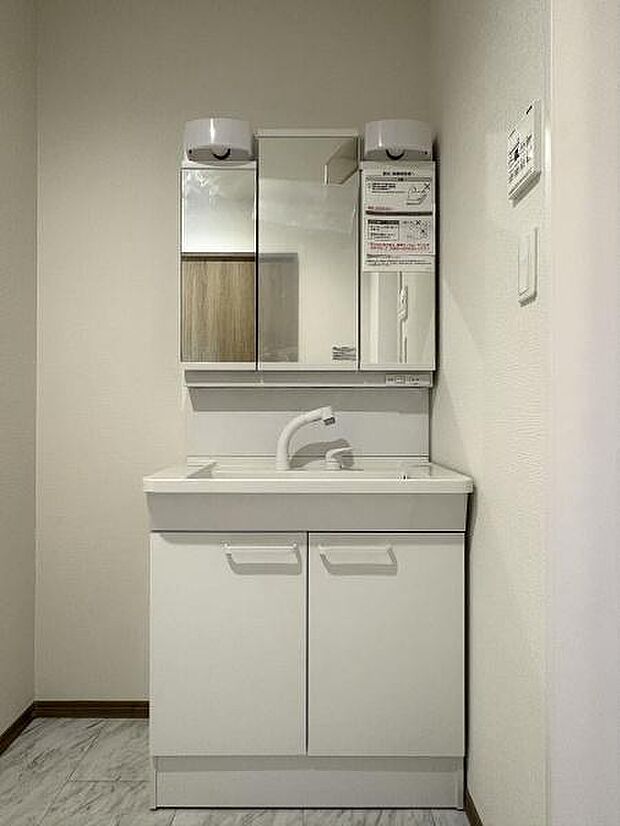 三面鏡付きの洗面台です。鏡裏にも収納可能。