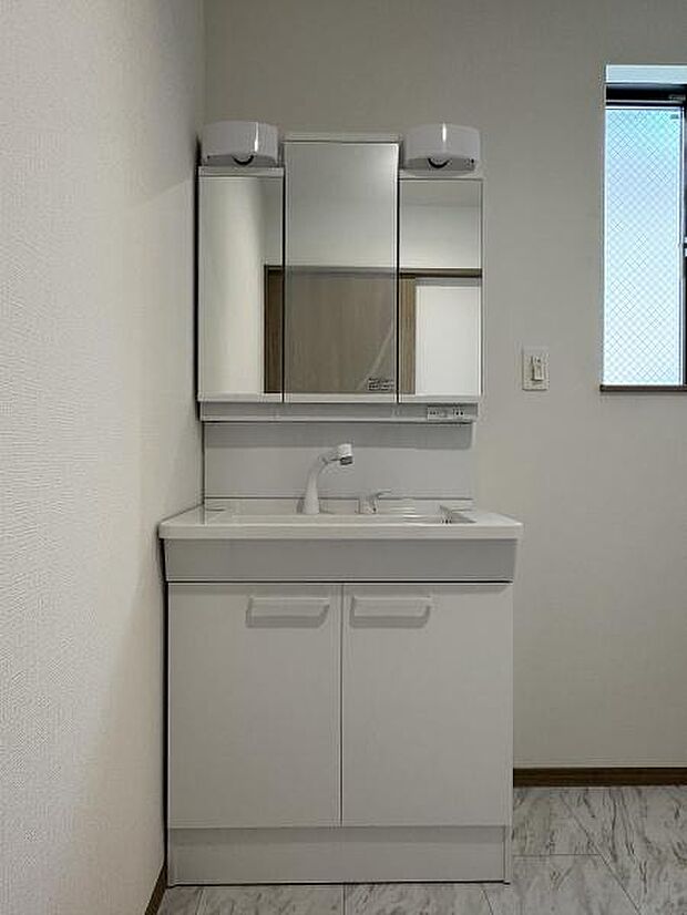 三面鏡付きの洗面台です。鏡裏にも収納可能。