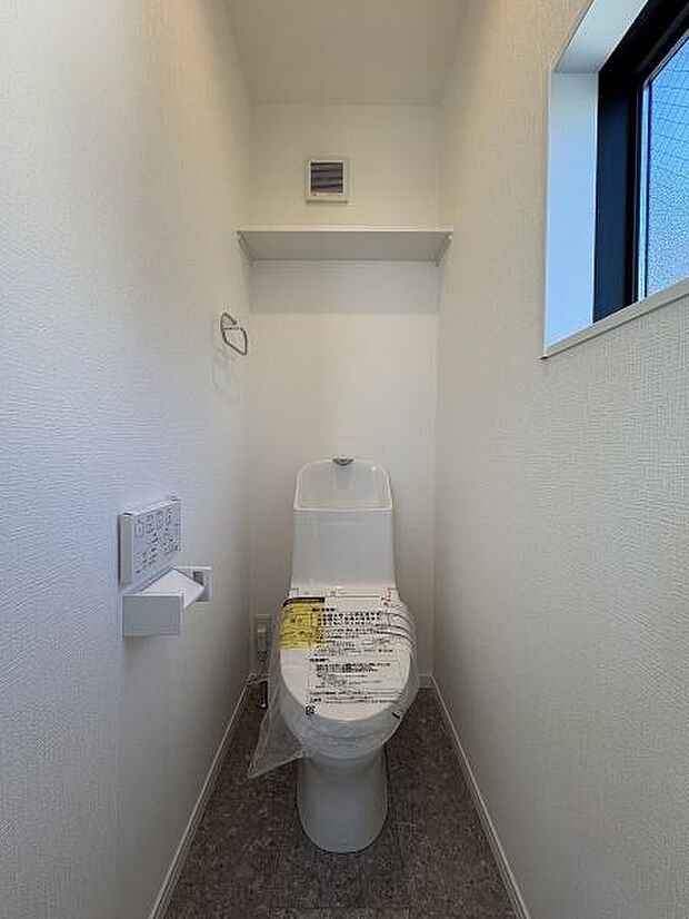 2階トイレ。お手洗いは温水洗浄便座です。ストックに便利な収納棚があります。