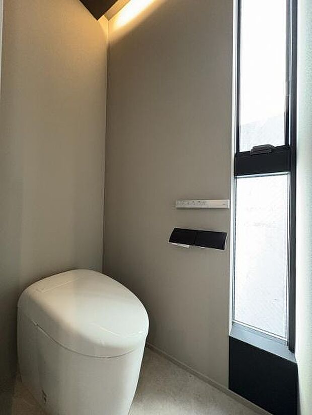 シンプルなトイレ内。タンクレス便座のため、すっきりしたイメージがあります。