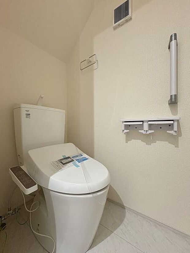 立ち上がりに便利な手すり付きのトイレ。温水洗浄便座です。(写真は1階トイレ)