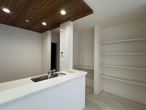 キッチンは対面式。近くにある収納スペースは可動棚となっています。