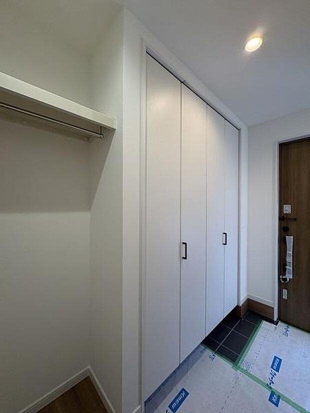 シューズボックスの他にコートやバッグ類も収納できるスペースを備えた玄関内。お客様用と家族用に出入口が分かれています。