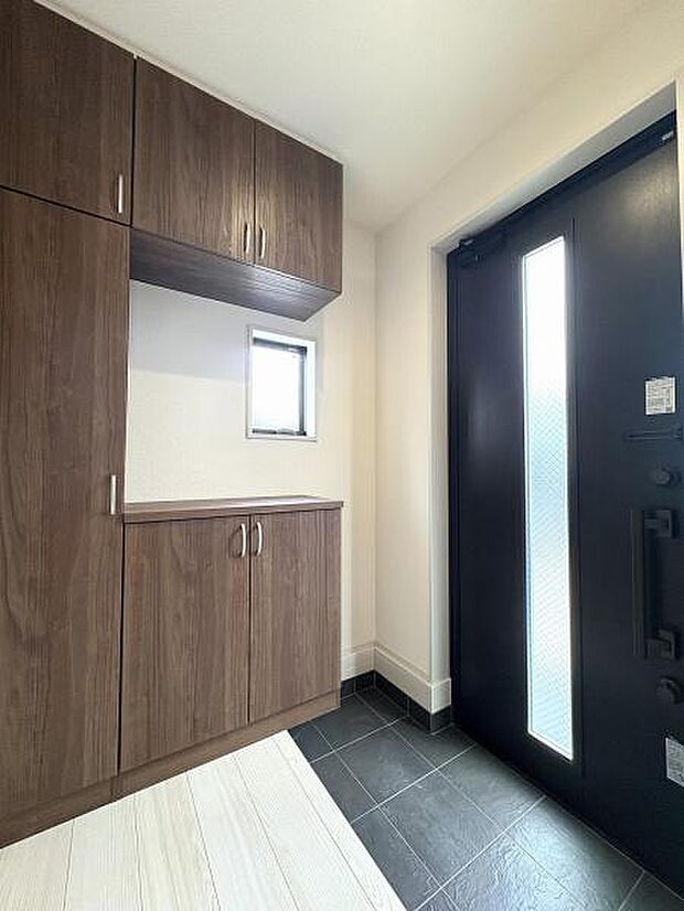 窓のある明るい玄関内。たっぷり収納できるシューズボックスを備えています。