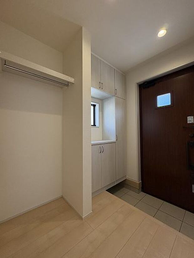 シューズボックスの他にコート類も収納できるスペースを備えた玄関内。