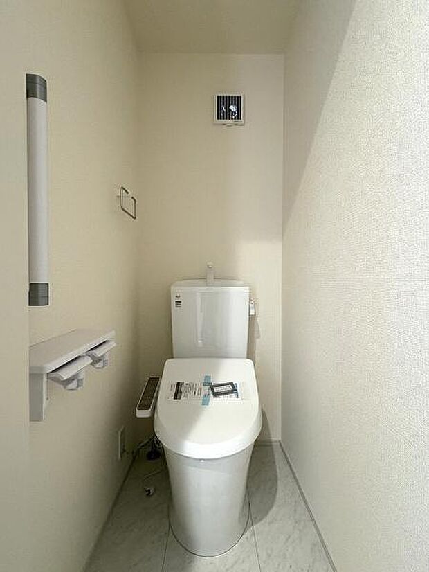 立ち上がりに便利な手すり付きのトイレ。温水洗浄便座です。