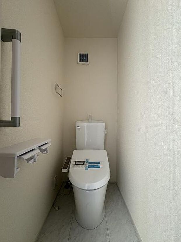立ち上がりに便利な手すり付きのトイレ。温水洗浄便座です。