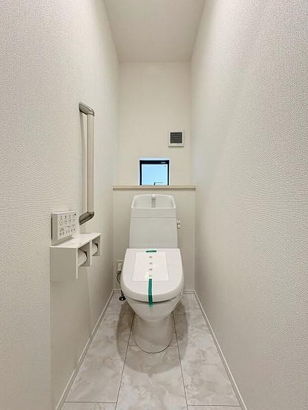 立ち上がりに便利な手すり付きのトイレ。温水洗浄便座です。