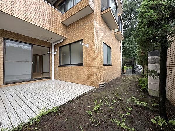 テラスに面した専用庭は緑に囲まれ、室内から一続きの景色として楽しめます。窓を開ければ庭の空気がそのまま部屋に流れ込み、季節の変化を日々の暮らしの中で身近に感じられます。