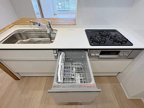 食洗機を引き出した状態のキッチンです。洗い物にかかる時間を短くしてくれる設備がリフォームで新しく加わっています。