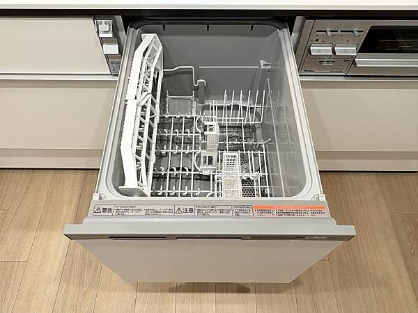 引き出し式の食洗機です。庫内が大きく開き、家族分の食器をまとめて収められる容量が確保されています。上段のカゴには箸やスプーンなど細かな道具も並べて置ける造りになっています。