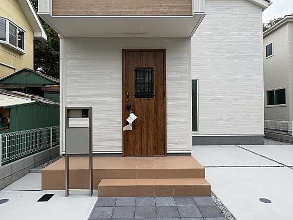 木目調の玄関ドアに、格子越しの明かり窓がやわらかな表情を添えています。