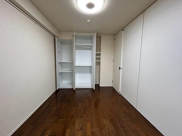 フローリングの洋室に、造り付けの収納が備わっています。パーテーションを閉めれば個室として、開け放つとリビングとの一続きの空間としてお使いいただけるフレキシブルなお部屋です。
