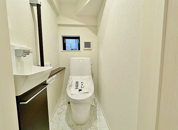 【1号棟】十分なスペースを確保したトイレ。収納もございますのでシンプルな空間を保てます。