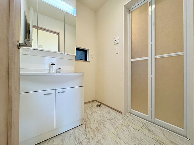 洗面化粧台は、鏡の裏側すべてが収納になった便利な三面鏡タイプ