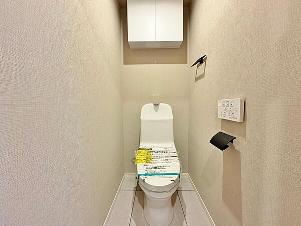 白を基調としたクリーンな印象のお手洗い。上部にはトイレットペーパーのストックなどに便利な吊戸棚が備わっています。毎日使う場所だからこそ、シンプルで落ち着く空間に。