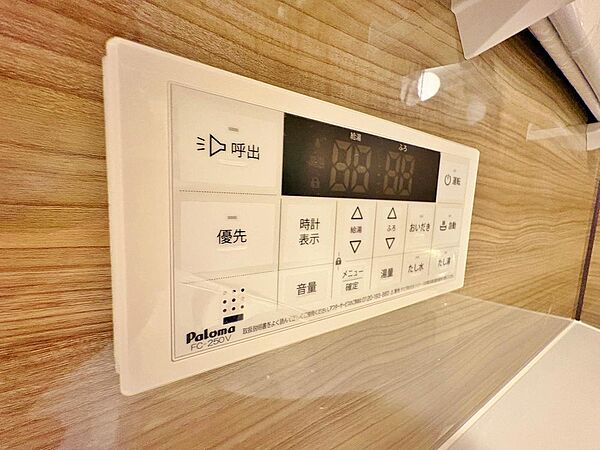 バスルーム内に設置された、木目調壁面に映える給湯器リモコン。入浴しながらの追い焚きや温度調節が手元でスムーズに行え、心地よいリラックスタイムを心ゆくまで堪能できます。