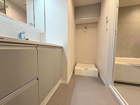 洗濯機置場の上部に扉付き吊戸棚を配置。洗剤のストックや生活感を隠して収納でき、すっきりと整理された快適なサニタリー空間を保てます