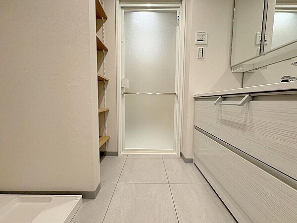 ワイドな引き出し収納を備えた洗面化粧台が、ホテルのような上品な佇まいを演出。リネン類の収納に最適な棚スペースも隣接し、機能美あふれる空間に仕上がっています。