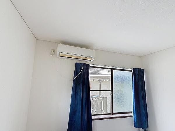 シンプルな内装の洋室です。エアコンが設置されており室内環境の調整が容易です。大きな窓からは自然光が入ります。カーテン付きで必要に応じて光の調整も可能です。使いやすさを感じられる空間です。