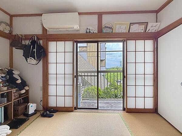 畳の温もりが感じられる落ち着いた和室です。障子から自然光が差し込み開放感のある空間となっています。収納スペースやエアコンも備わっており快適に過ごせます。バルコニーへもすぐにアクセス可能です。
