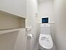 トイレ：シンプルですっきりとした空間が特徴のトイレです。壁面収納が備え付けられており小物の整理に便利です。窓があり採光を取り入れやすい設計です。温水洗浄便座付きで使いやすさにも配慮されています。