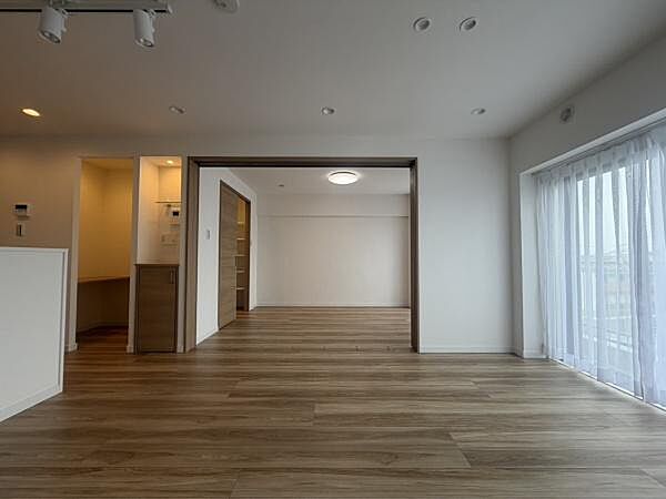 大きな窓からたっぷり光が差し込むリビングです。開放感のある広々とした空間が広がっています。フローリングは明るい色合いで室内がすっきりとしています。