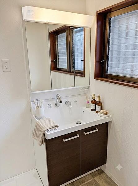 明るい照明が備わった洗面台で鏡も大きく使いやすい空間です。収納も充実しているので日用品の整理がしやすく便利です。インテリアなどはAIを使用したCGによる合成画像です。