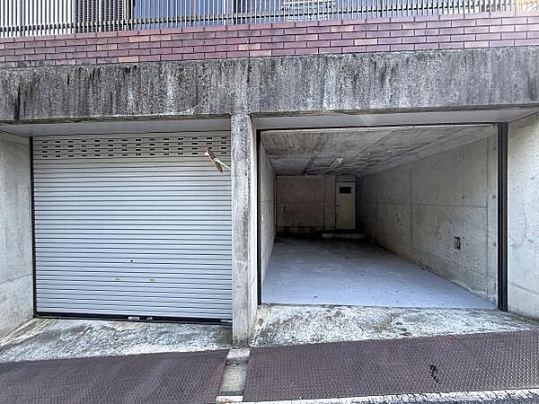 コンクリート造りのしっかりとした駐車場です。シャッター付きで車両の保管に安心感があります。出入口も広く使い勝手の良い設計です。建物と一体となった駐車スペースです。