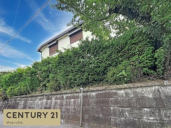 落ち着いた雰囲気の住宅外観が特徴です。フェンスに沿った豊かな植栽がプライバシーを保ちながら自然を感じられます。しっかりとした石積みの塀が安心感を与え青空と緑のコントラストが際立ちます。