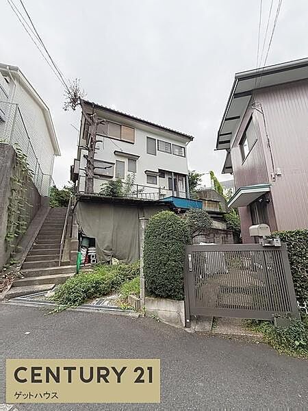 現地写真では落ち着いた雰囲気の住宅地が広がっています。前面道路は車通りが少なく安心感が得られます。周辺は緑も見られ日々の暮らしをサポートする環境が整っています。建物の外観も明るい印象を持っています。