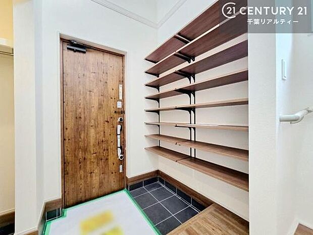 木の温もりを感じる玄関ドアと、見せる収納としても楽しめる可動棚を設けたシューズスペース。すっきりとした空間ながら収納力もあり、機能性とデザイン性を兼ね備えた玄関です。