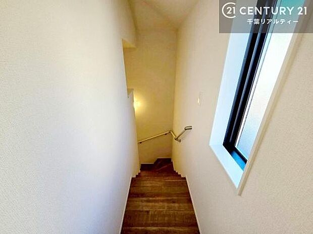 窓から自然光が差し込む明るい階段スペース。手すり付きで安心して昇り降りでき、ご家族みんなにやさしい設計です。