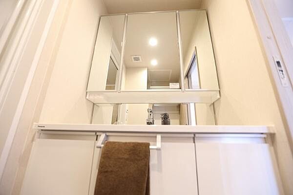 洗面化粧台には、一体型の洗面ボウルを採用しており、お手入れのしやすい仕様となっております。また、三面鏡の裏側には収納スペースが設けられており、小物類もすっきりと整理・収納いただけます。