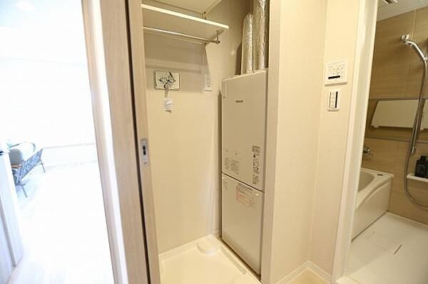 洗濯機置き場には、防水パンおよび洗濯機用水栓を備えております。また、上部には収納に便利な棚を設置しております。