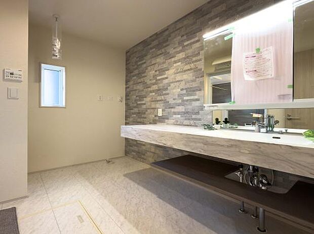 ホテルのような気品漂う洗面室。大理石調のカウンターと石目調の壁が日常を格上げし、毎日の身支度を特別なひとときへと変えてくれます。