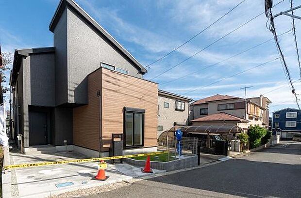 青空に映えるシャープな片流れ屋根が、道行く人の目を惹くデザイン住宅。木目の外壁がモダンな中に温かみを添えています。