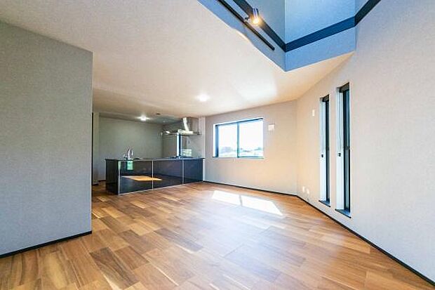 印象的な吹き抜けとデザイン窓が、室内に豊かな光と開放感を届けます。木の温もりとモダンが調和した空間です。